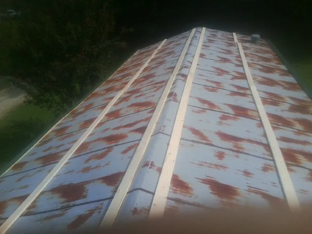 Rusted metal roof panels with new wood purlins before replacement — Storm Damage Roof Repair in New Eagle by Roofing Brothers