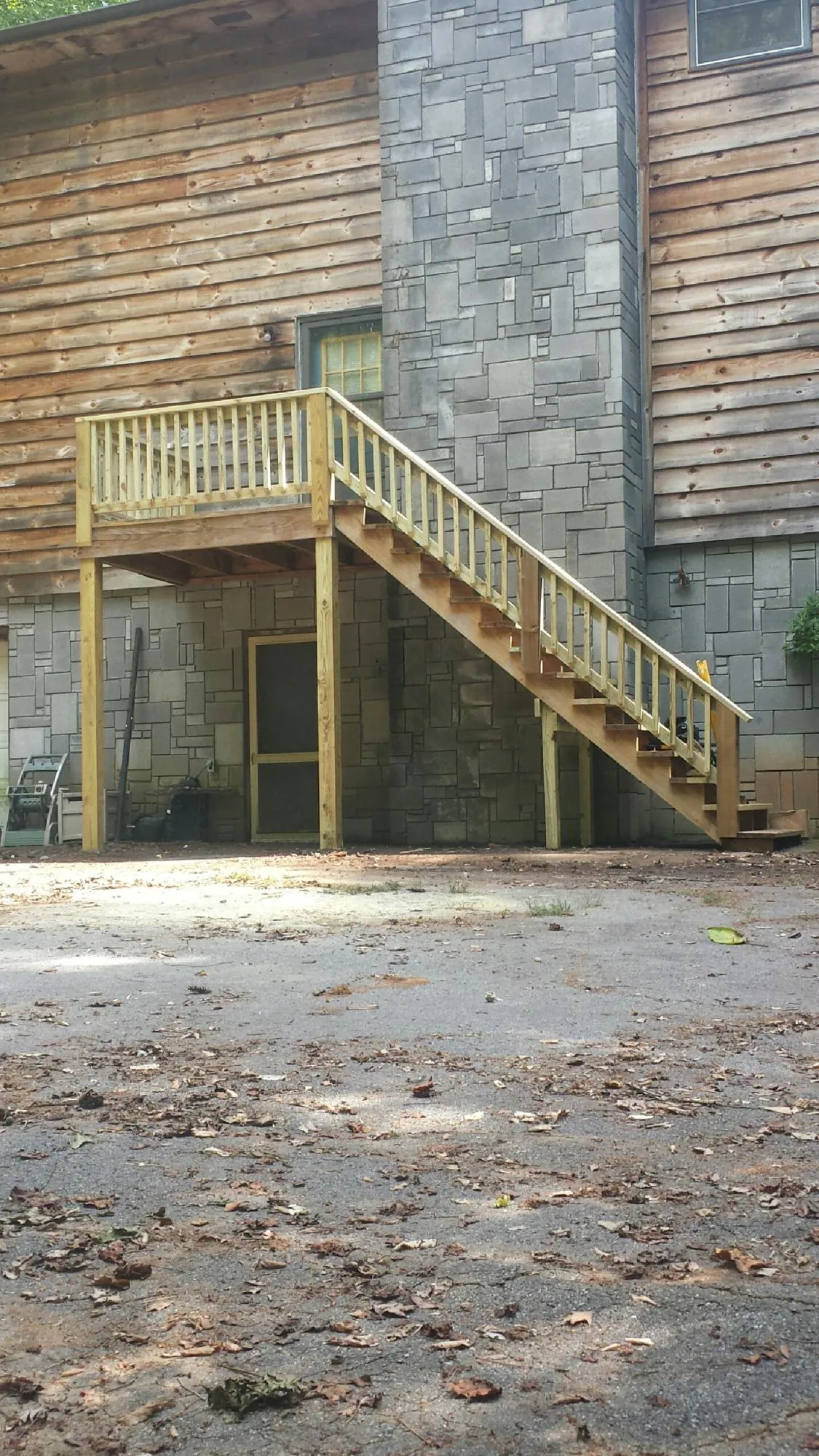 New pressure treated deck and stair landing on a log home in New Eagle
