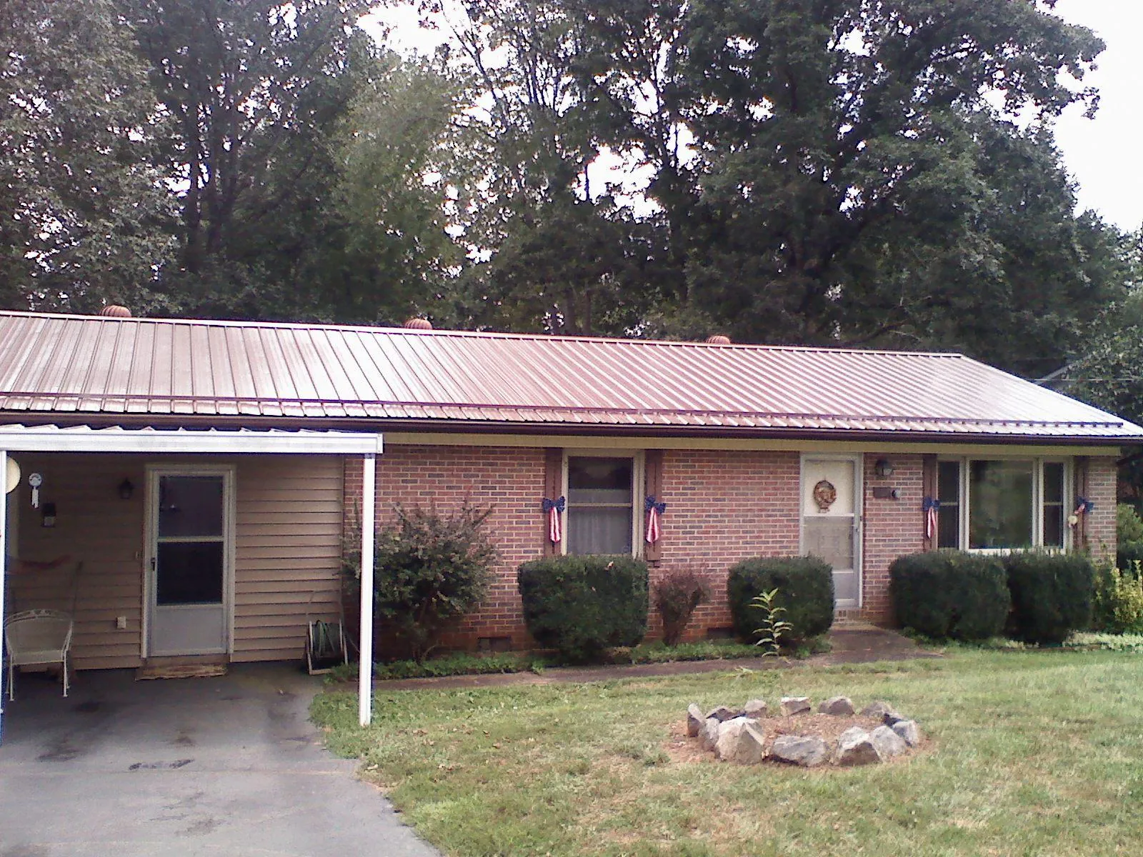 Bronze metal roof and carport on a brick ranch home — Roof Repair work by our crew in New Eagle